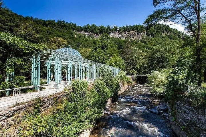 Stream flowing through Borjomi Central Park alongside a walkway and glass structure