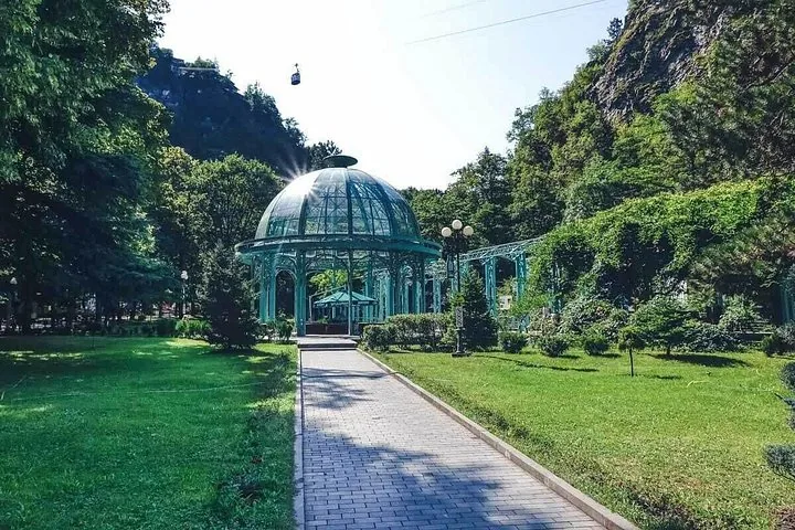 Glass dome structure and pathways in Borjomi Central Park on a sunny day