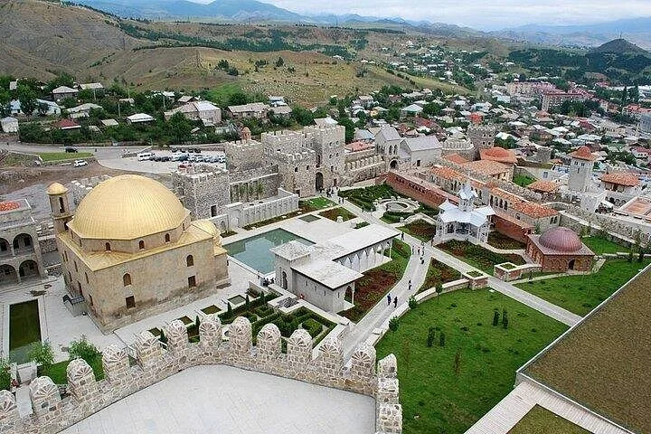 High-angle daytime shot of the Rabati Castle grounds, gardens, and golden-domed mosque